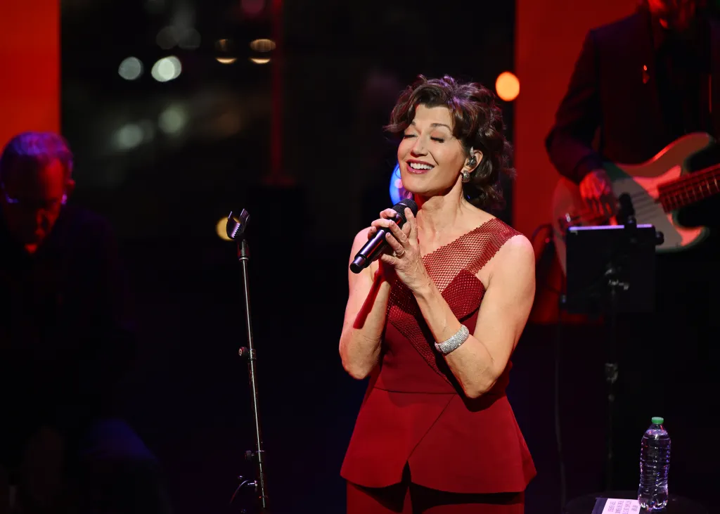 Amy Grant performing onstage in a red dress.