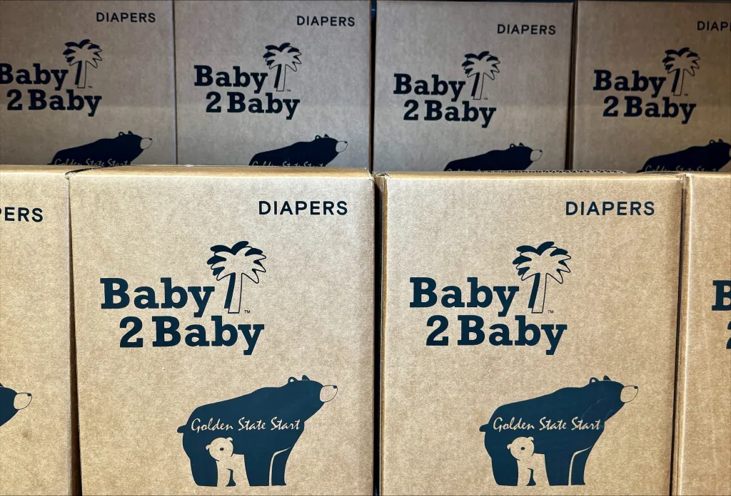 Stacks of "Baby2Baby" branded diaper boxes.