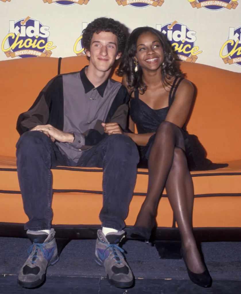 Actor Dustin Diamond and actress Lark Voorhies sitting on an orange couch at the Nickelodeon Kid's Choice Awards.