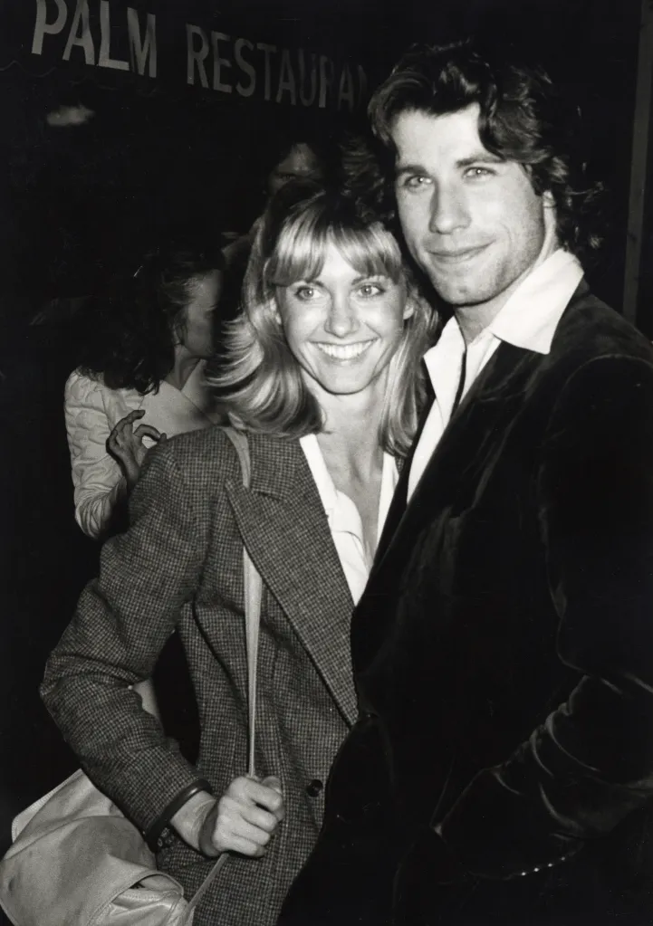 John Travolta and Olivia Newton-John smiling at the Palm Restaurant in Beverly Hills.