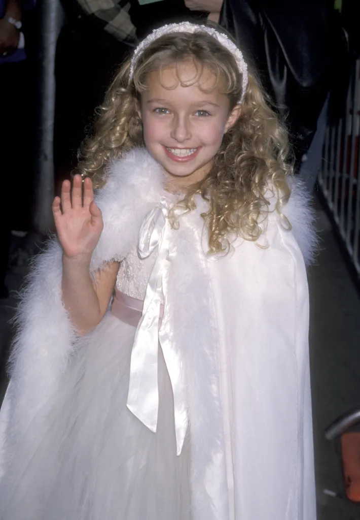 Hayden Panettiere in a white furry cape and dress, waving at the A Bug's Life premiere.