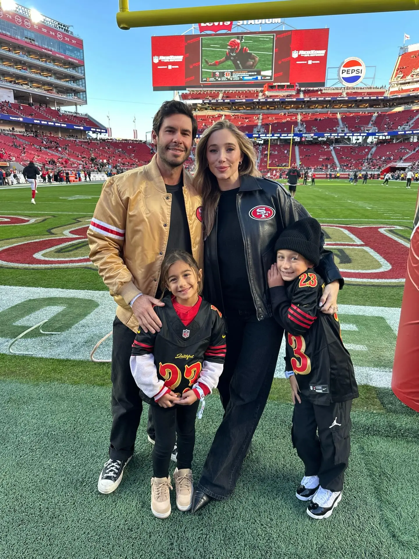 Aurora Culpo and her family on the field of a football stadium.