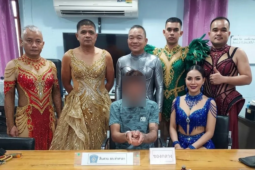 Police officers dressed in elaborate costumes posing with a handcuffed suspect.