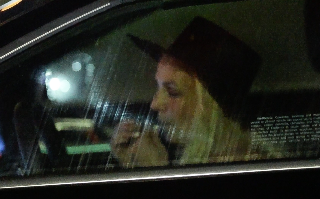 Britney Spears in a car wearing a dark hat.