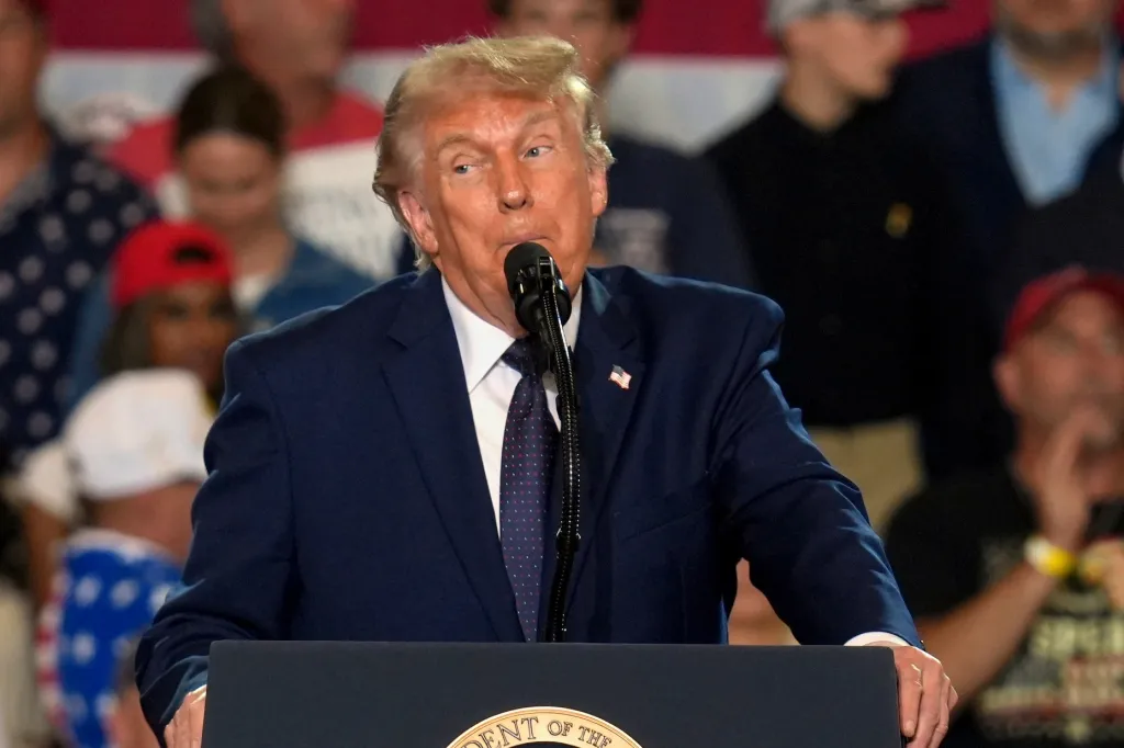 Donald Trump speaking at a podium during a "Fighting For American Workers" event.