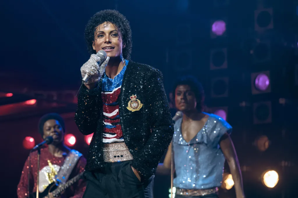 Jaafar Jackson as Michael Jackson, Rhyan Hill as Tito Jackson, and Tre' Horton as Marlon Jackson performing on stage.