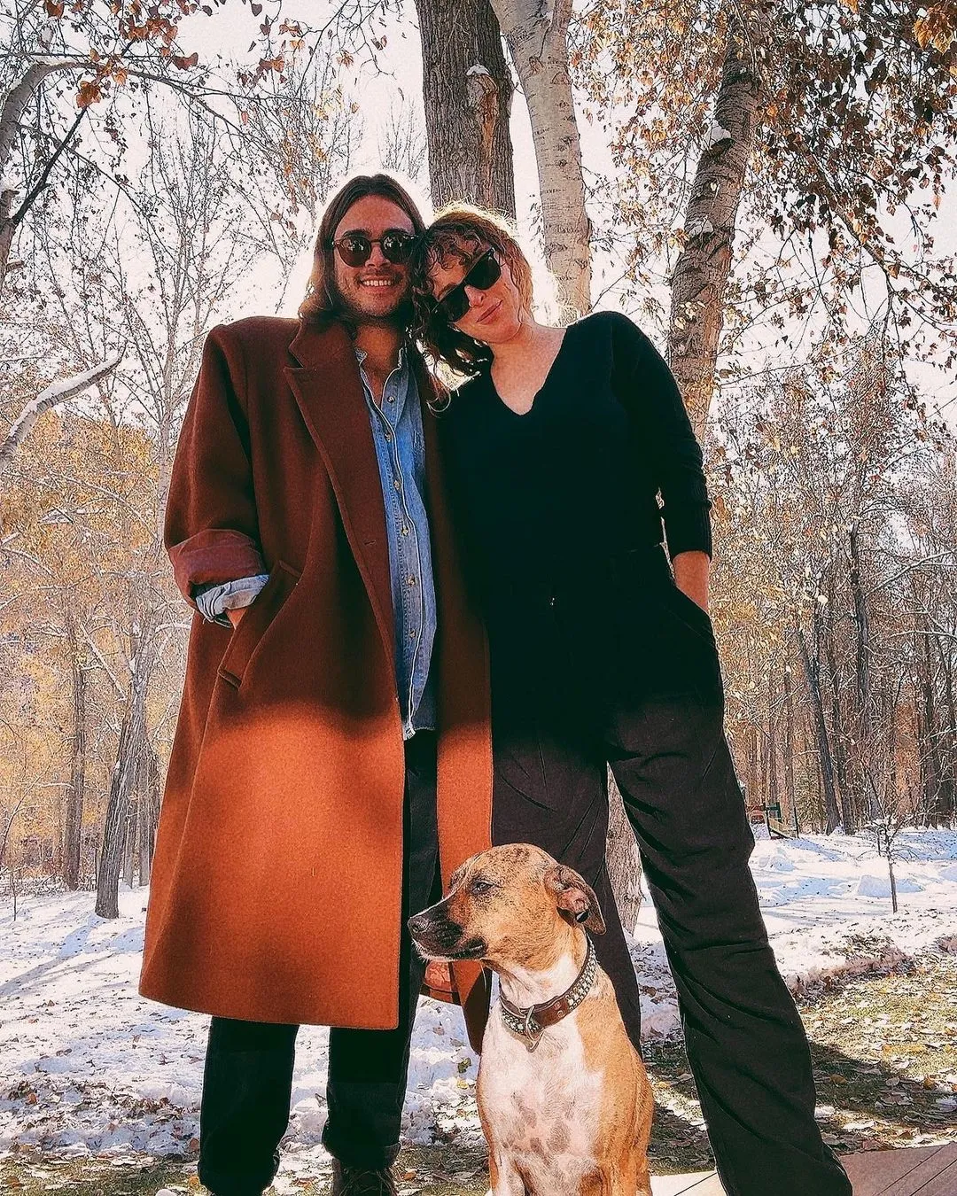 Rumer Willis posing outdoors in the snow with a man and a dog.