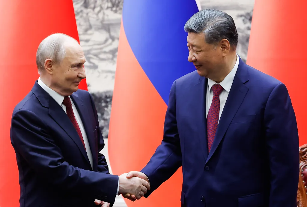 Russian President Vladimir Putin and Chinese President Xi Jinping shake hands.