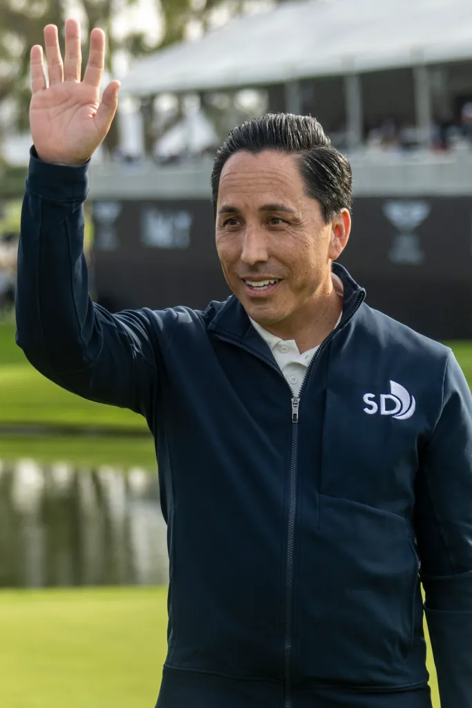 San Diego Mayor Todd Gloria waves to the crowd at the Genesis Invitational tournament.