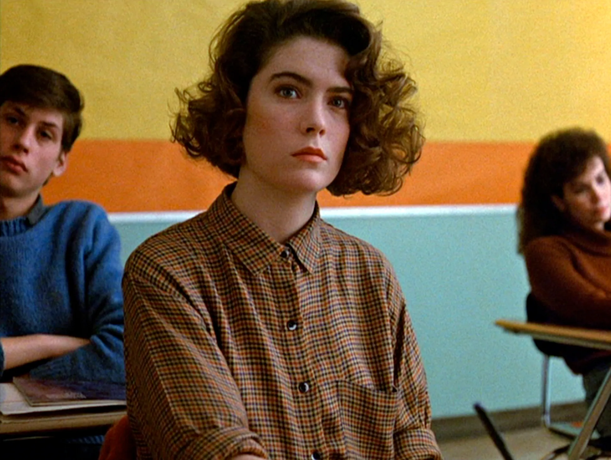 Lara Flynn Boyle as Donna Hayward sits at a classroom desk in a still from "Twin Peaks."