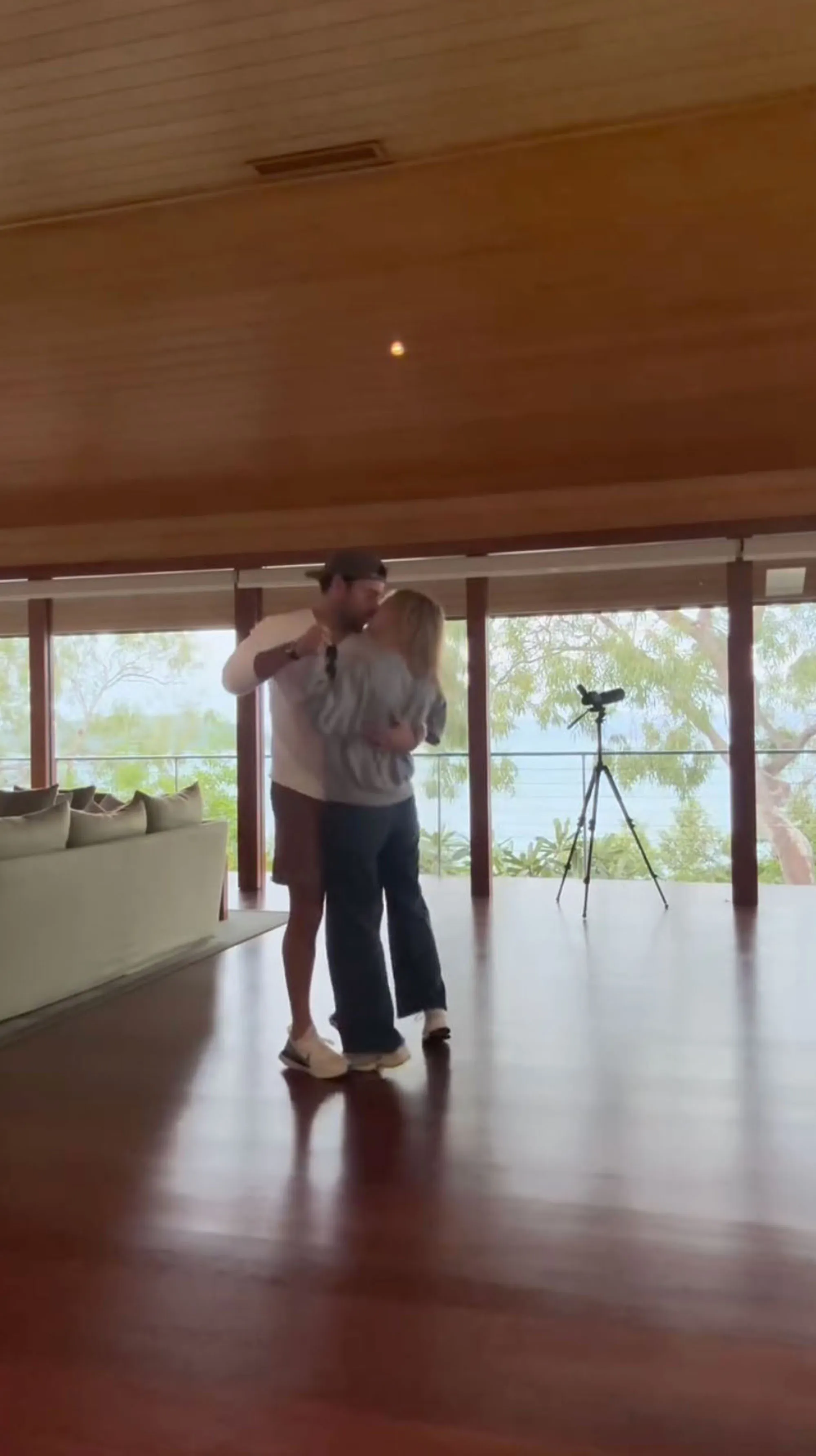 Sydney Sweeney and Scooter Braun embracing in a room with a view of the ocean.