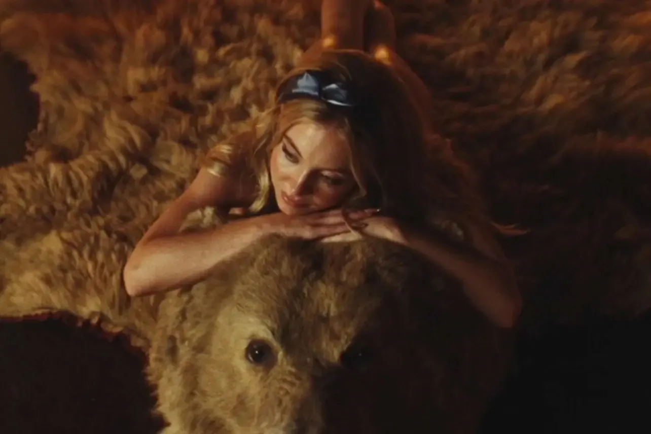 Cassie (Sydney Sweeney) poses on a bearskin rug, as part of Nate's fantasy.