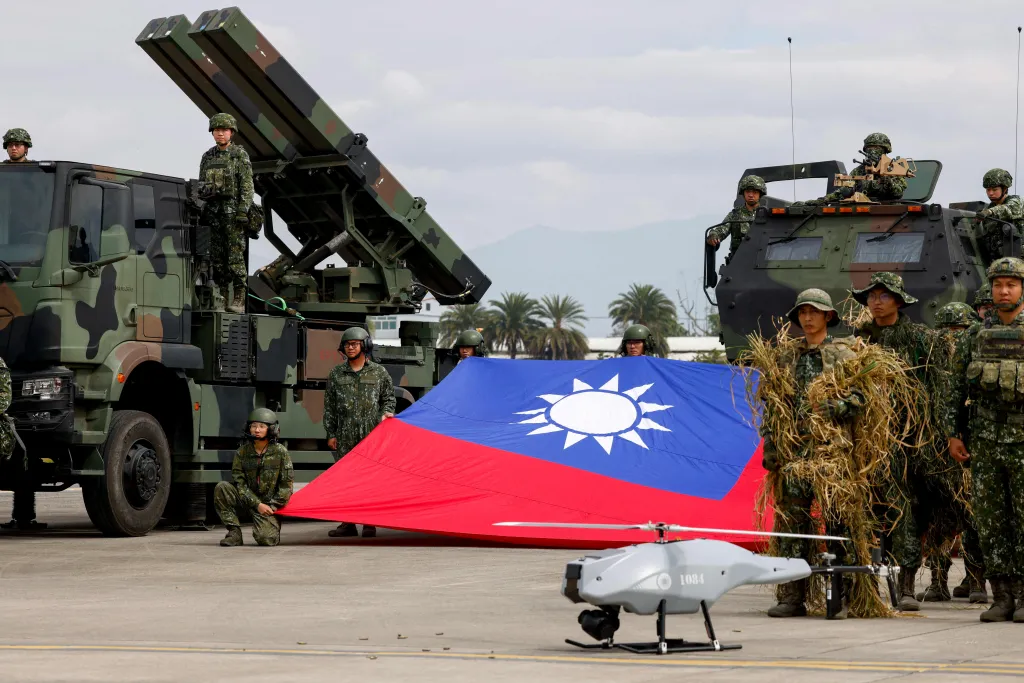 Taiwanese soldiers pose with a Taiwanese flag, a Sky Sword II surface-to-air missile launcher, and a military UAV during an annual military exercise.
