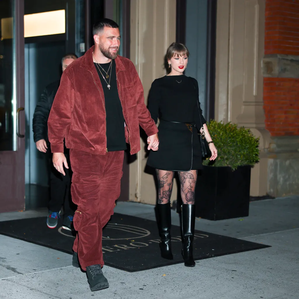 Taylor Swift and Travis Kelce holding hands while walking in New York City.