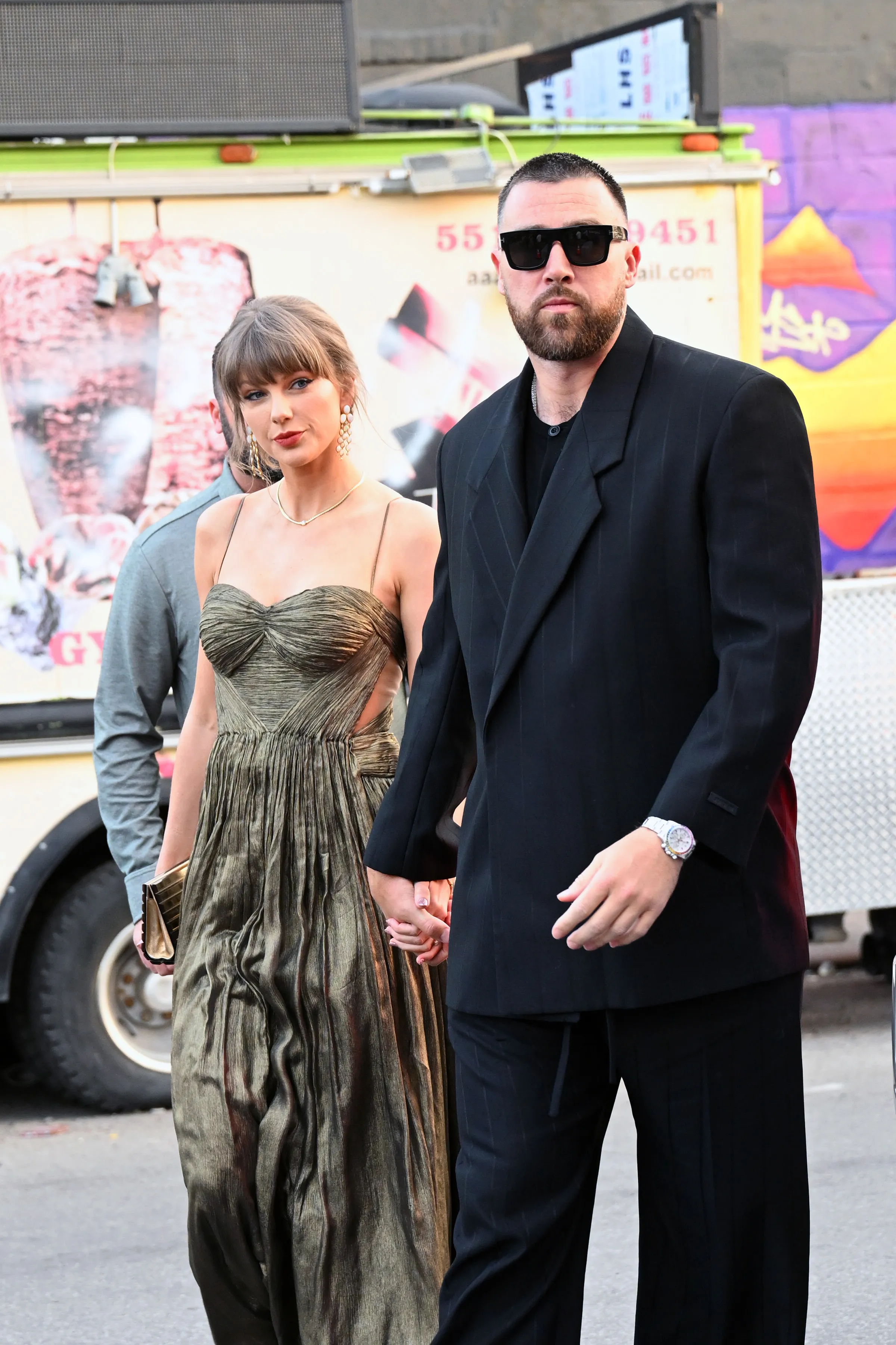 Taylor Swift and Travis Kelce holding hands while walking in New York City.