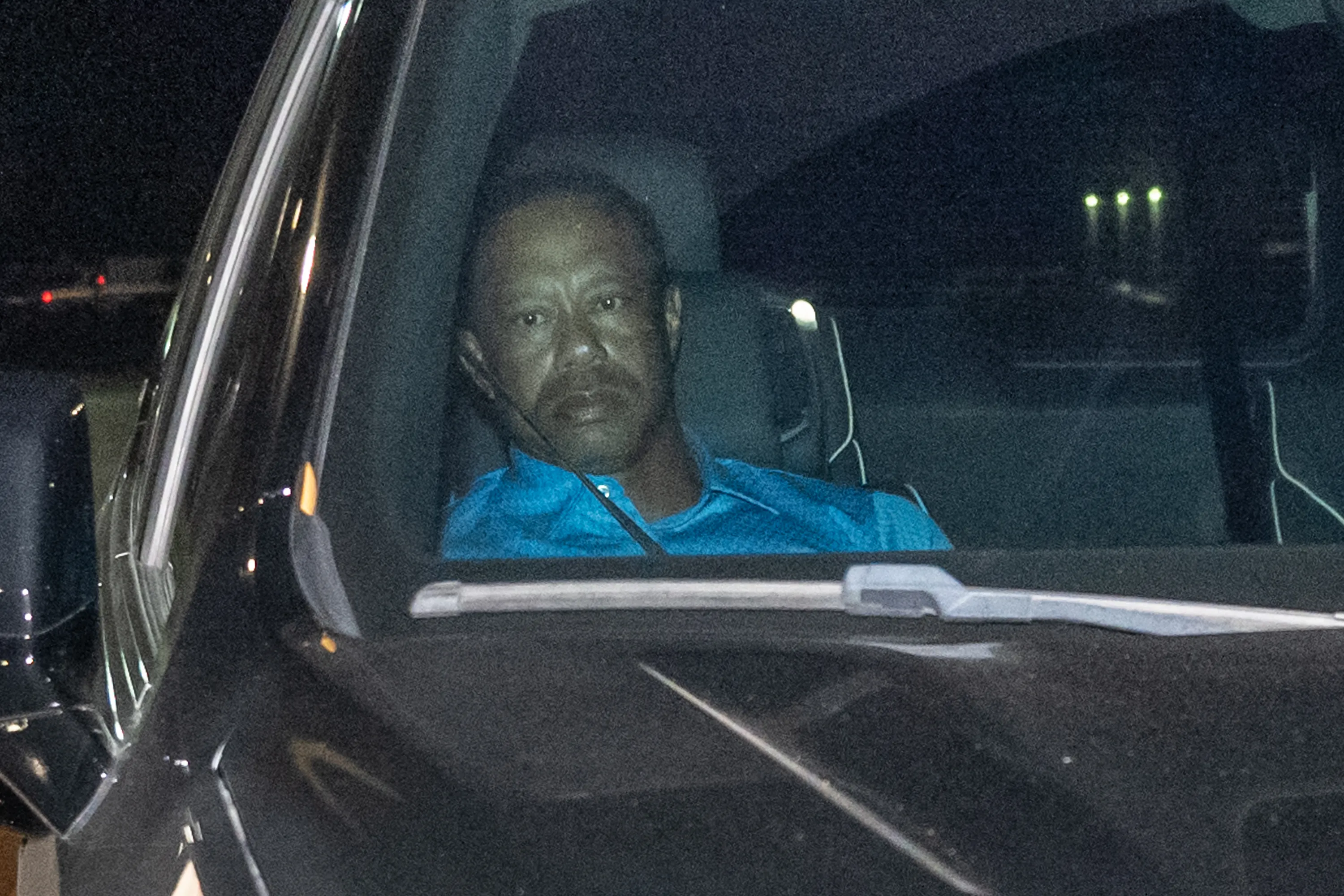 Tiger Woods sitting in a vehicle at night.
