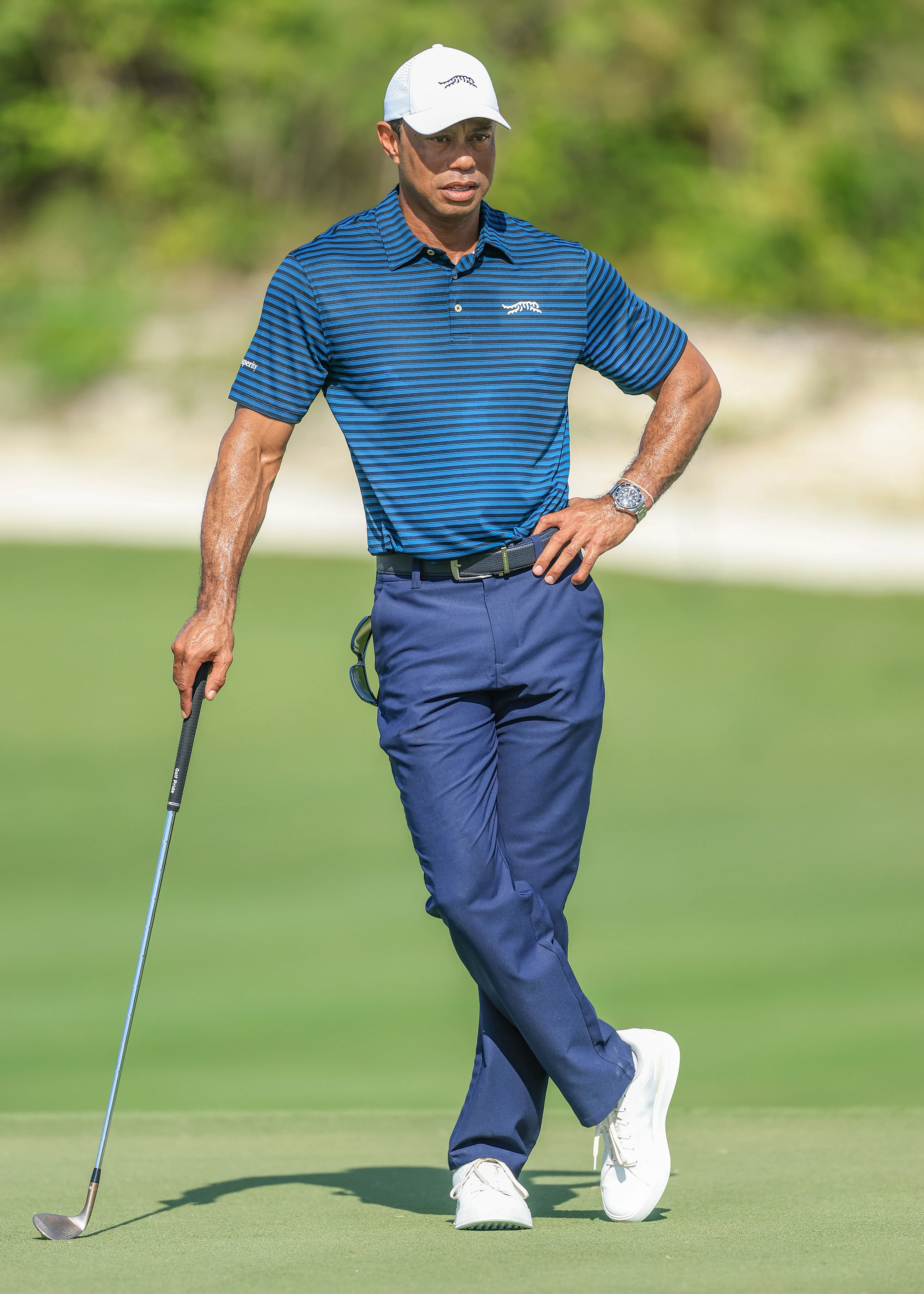 Tiger Woods holds a golf club while watching a pro-am prior to the Hero World Challenge 2025.
