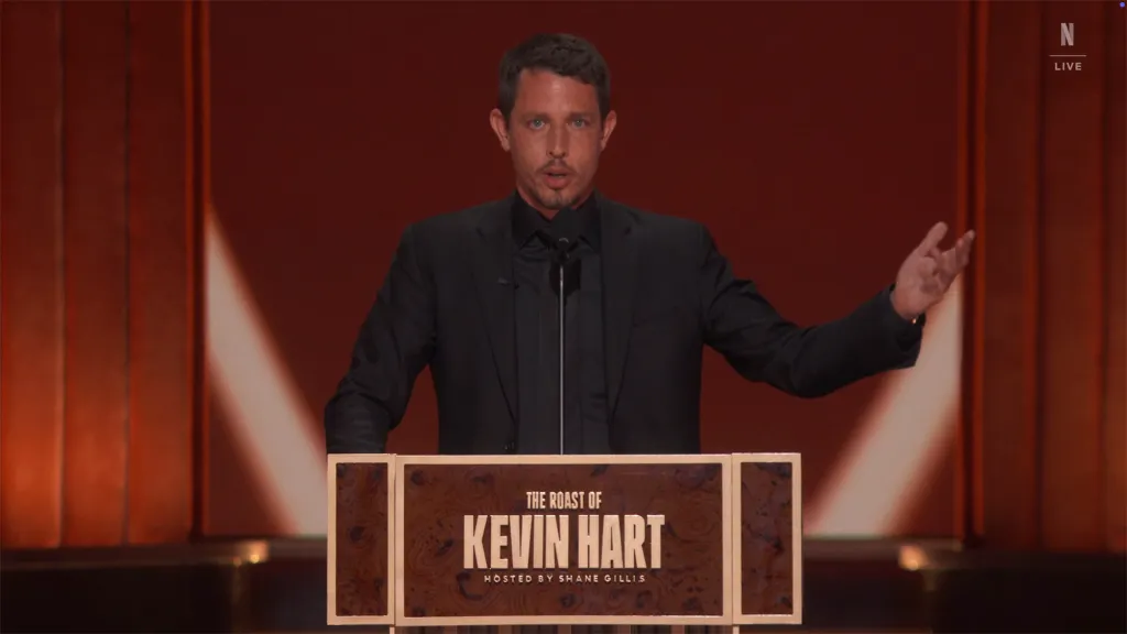 Comedian Tony Hinchcliffe speaking at a podium during "The Roast of Kevin Hart".