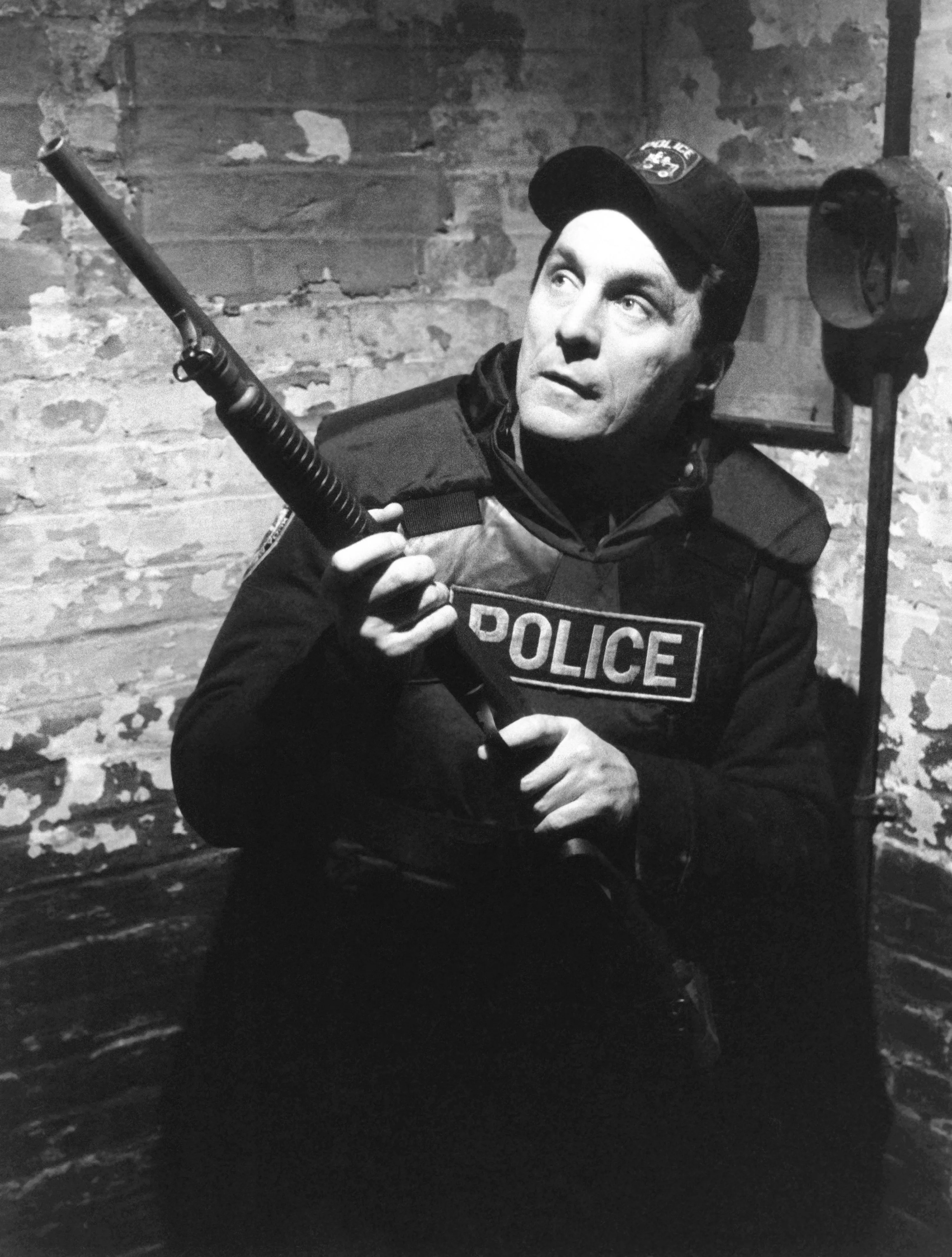 Beau Starr as a police officer in the television series "True Blue," holding a shotgun.