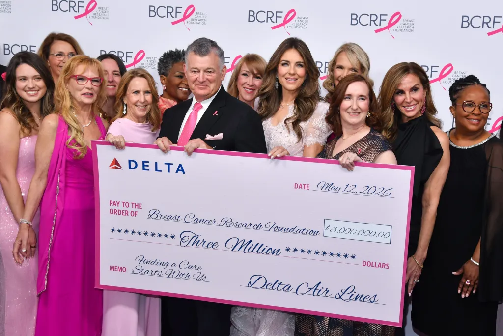 William P. Lauder and Elizabeth Hurley with others holding a large check for $3,000,000 made out to the Breast Cancer Research Foundation.