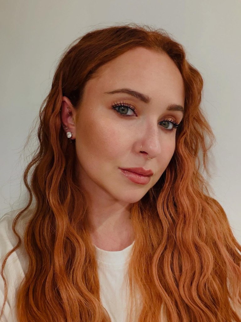 Hayden Panettiere looking directly at the camera with her wavy red hair cascading over her shoulders.