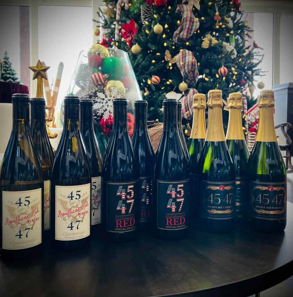 Bottles of "Republican Red Winery" brand wine and champagne displayed in front of a Christmas tree.