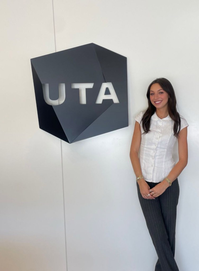 Skyler Moses standing next to a black "UTA" sign.