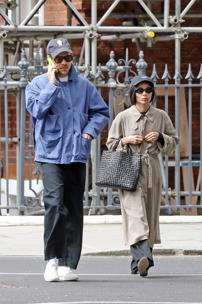 Harry Styles on the phone and Zoe Kravitz wearing a cap that says "Kiss" on the front.
