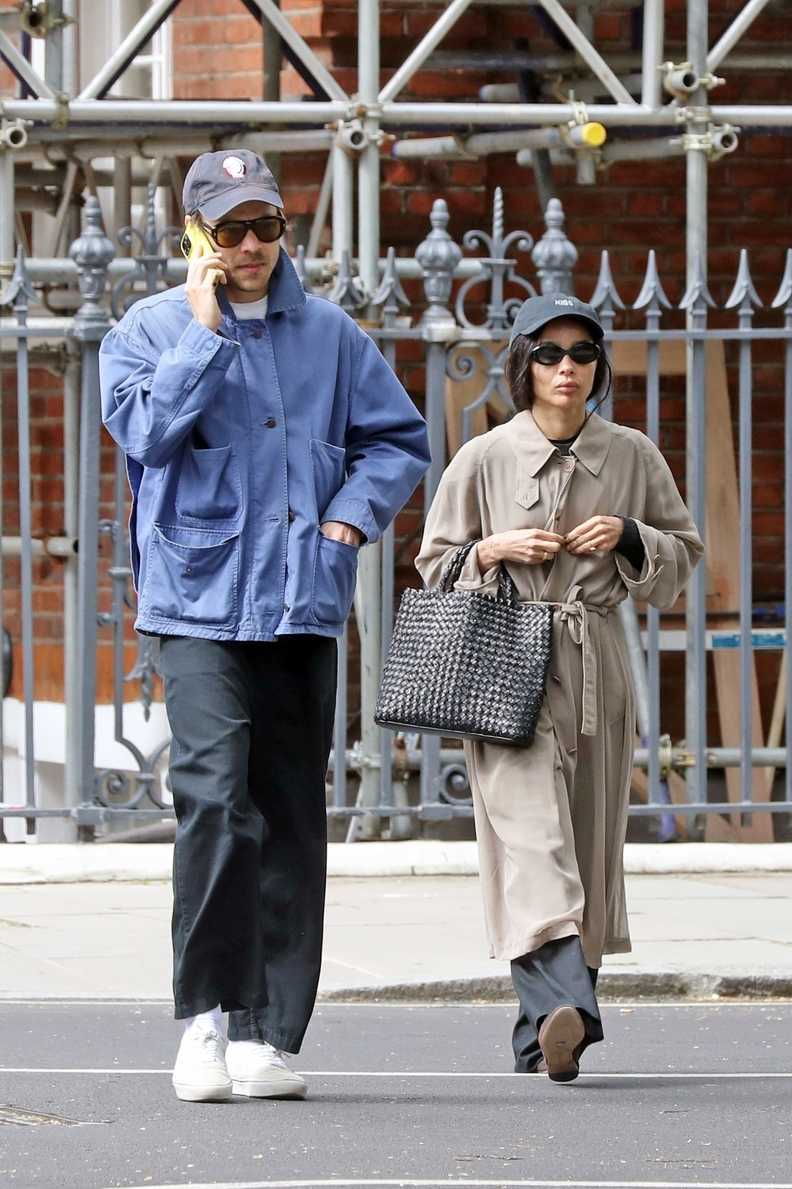 Harry Styles and Zoë Kravitz walk down a street, Harry on the phone.