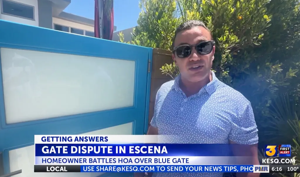 Man in sunglasses standing in front of a blue gate with news text "GATE DISPUTE IN ESCENA HOMEOWNER BATTLES HOA OVER BLUE GATE."