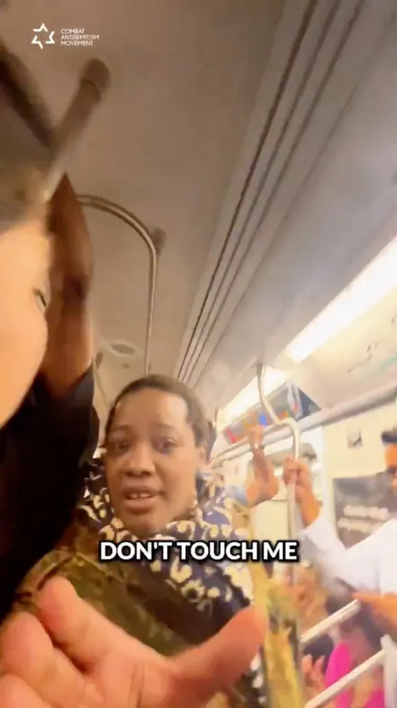 Woman on a subway train pushing away a camera, with the text