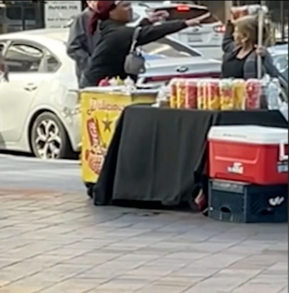 Two street vendors in Los Angeles arguing in front of their carts.