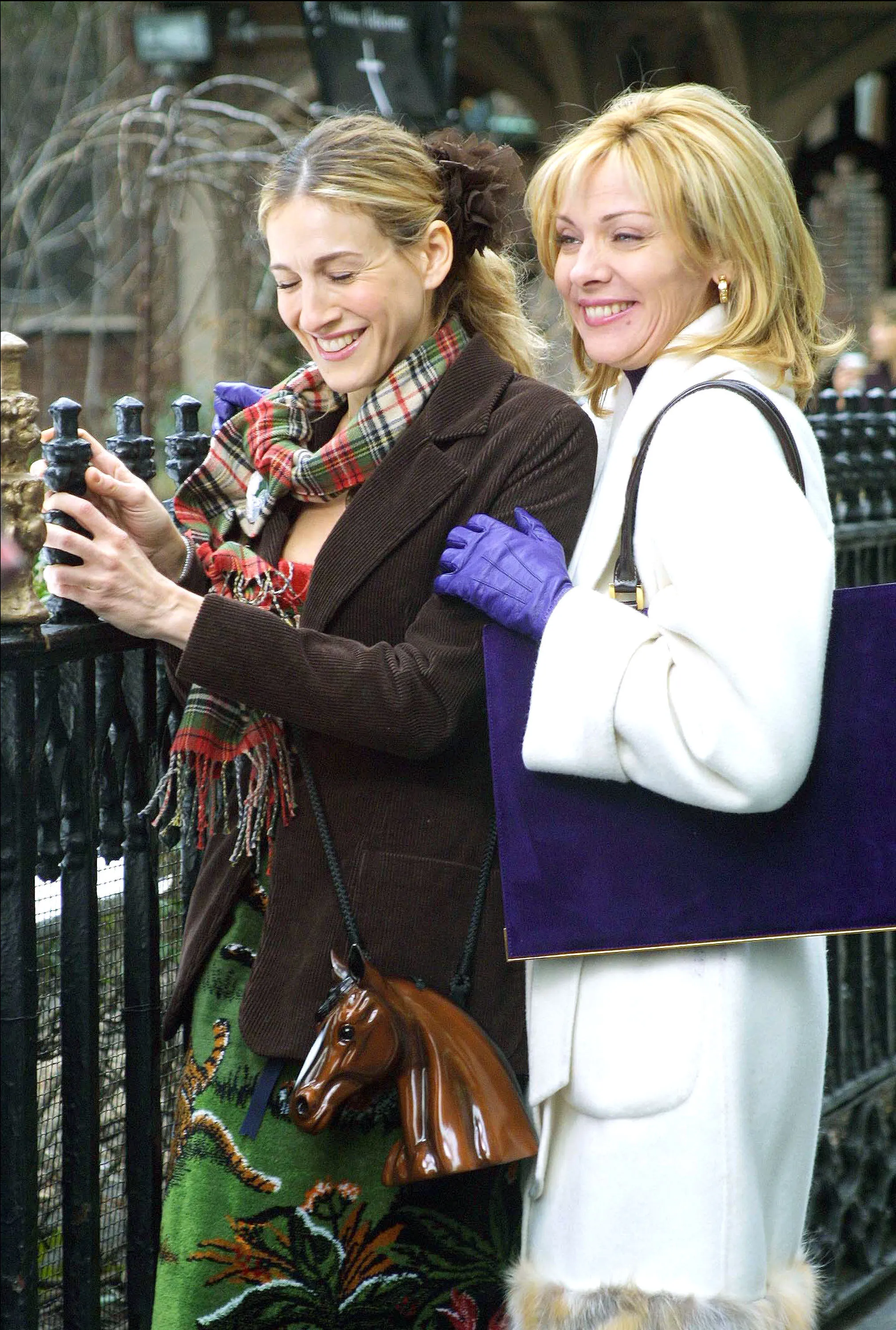 Sarah Jessica Parker and Kim Cattrall smiling while filming "Sex and the City."