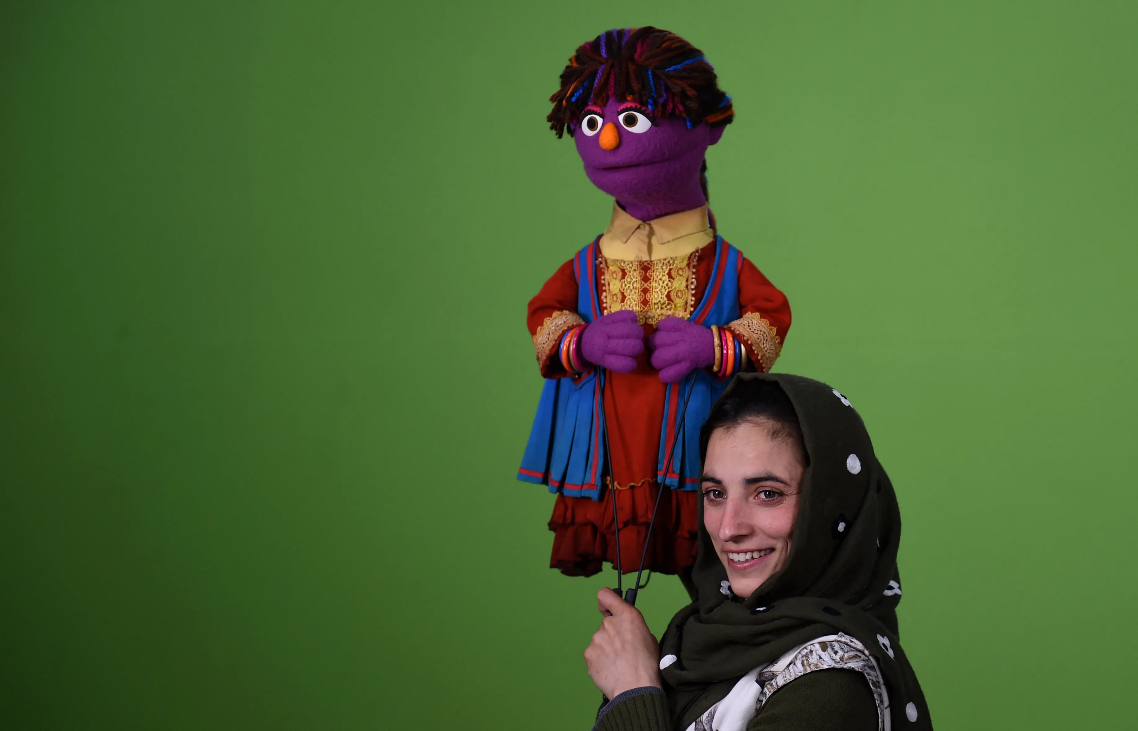 An Afghan puppeteer holds a muppet named "Zari" for a television program on April 10, 2016.