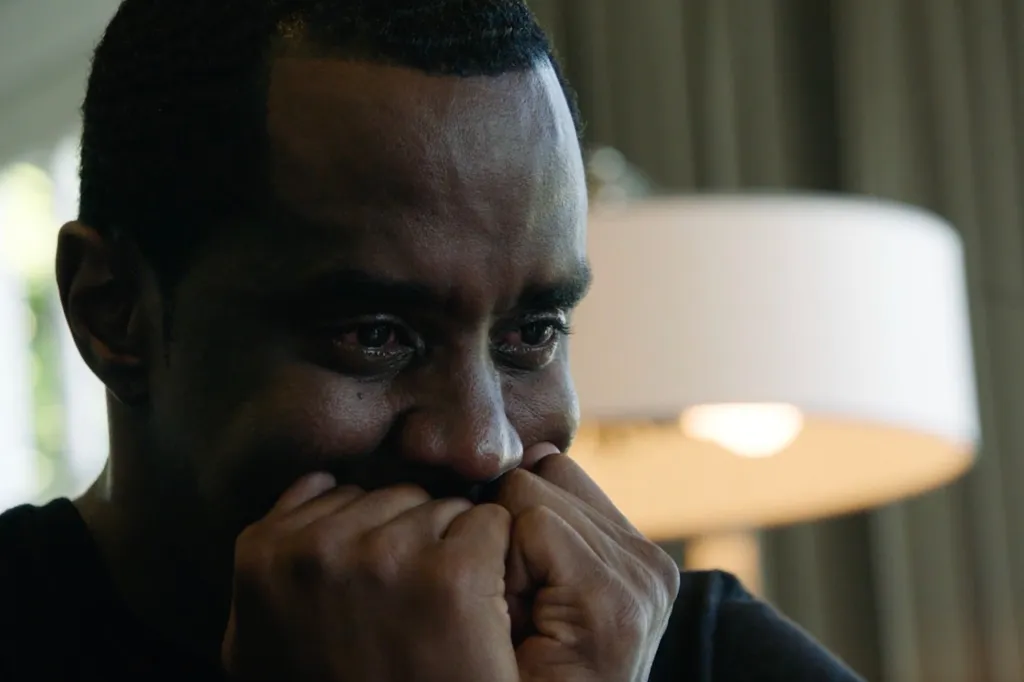 Sean "Diddy" Combs crying, with hands near his mouth.