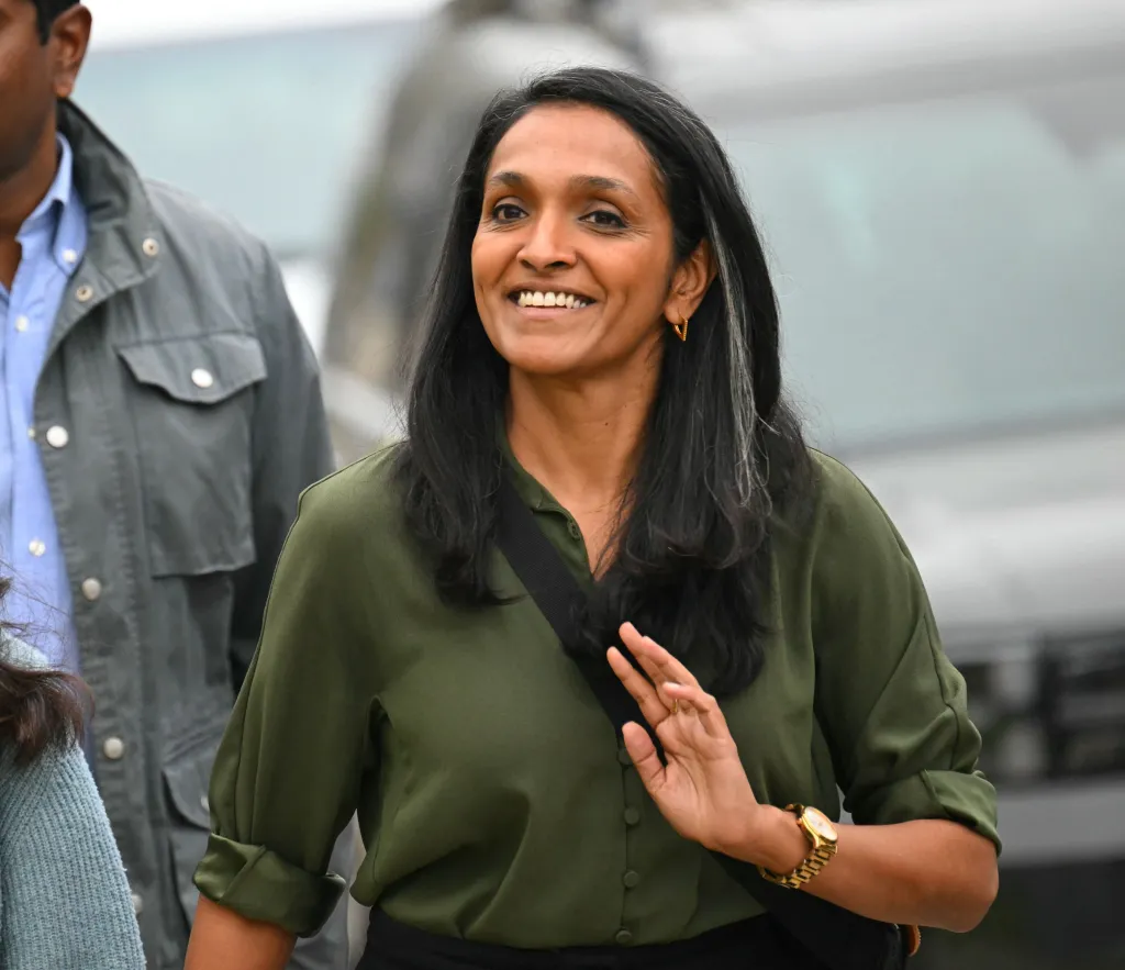 Los Angeles Councilmember Nithya Raman smiling and waving, accompanied by her family, after casting her vote in California's primary election.