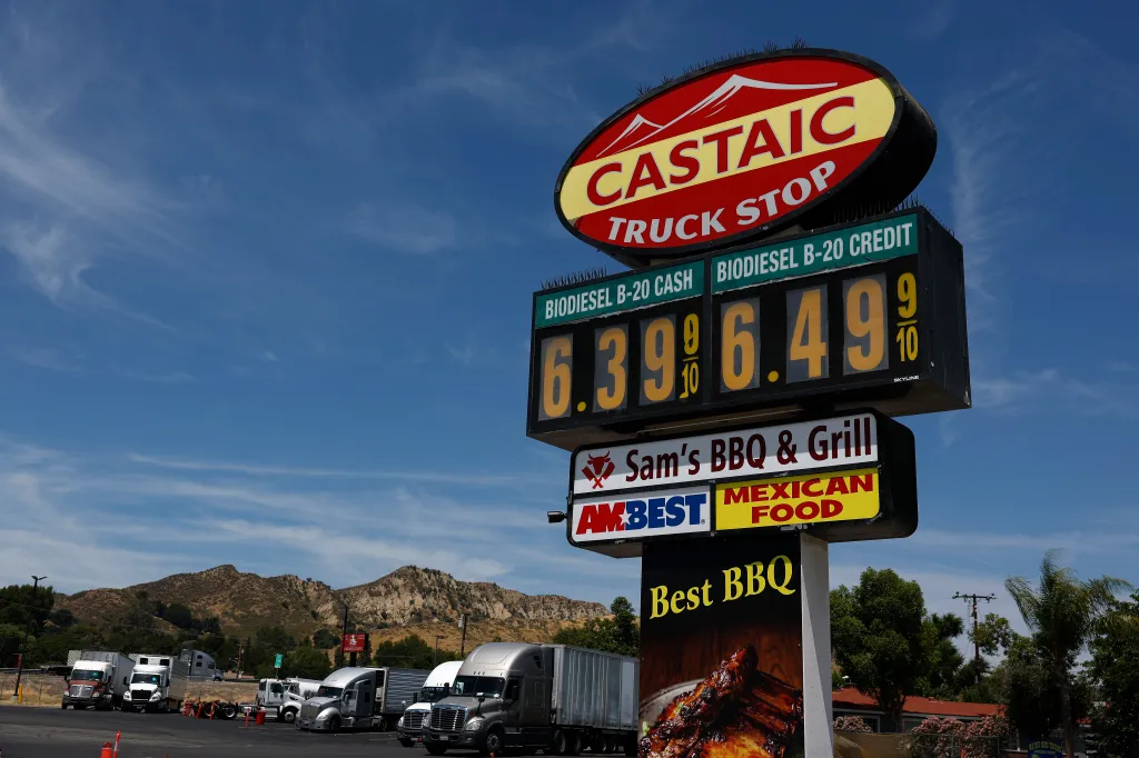 Trucks parked by a sign showing biodiesel prices over $6 a gallon.