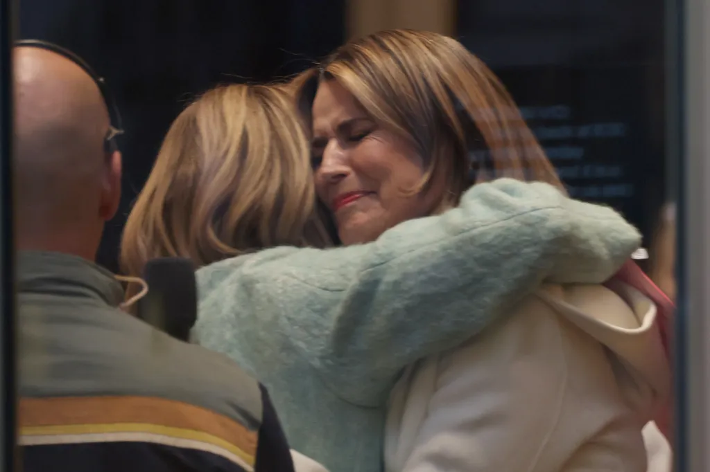 Savannah Guthrie embraces a colleague, her eyes closed in emotion, on her return to the "Today" show.