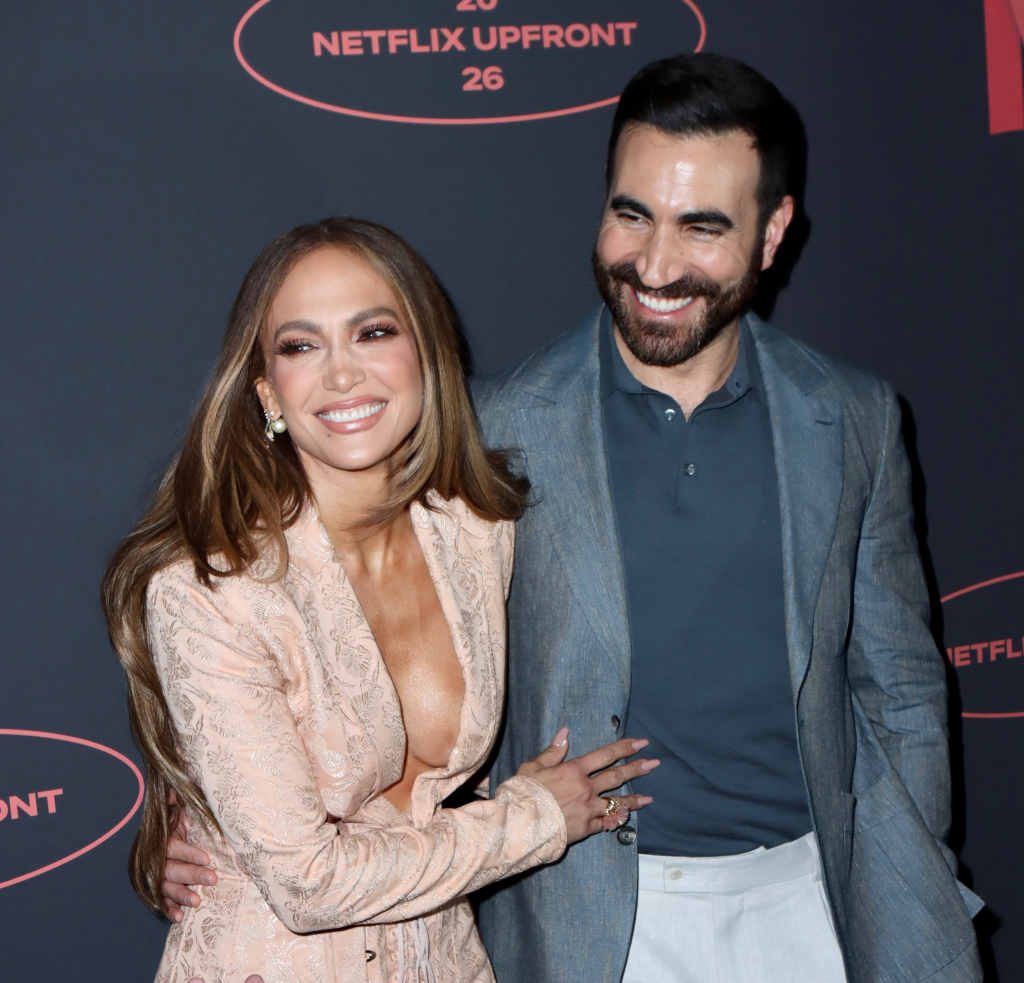 Jennifer Lopez and Brett Goldstein smiling at the 2026 Netflix Upfront event.