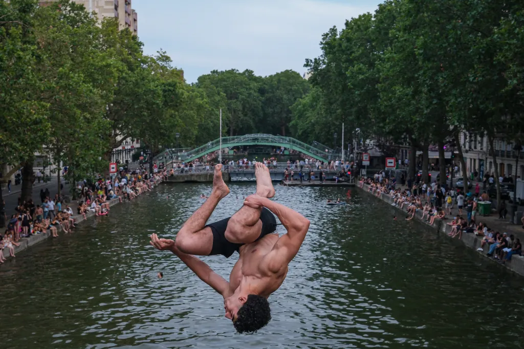 A man performs a backflip into the Canal Saint-Martin in Paris during a heatwave.