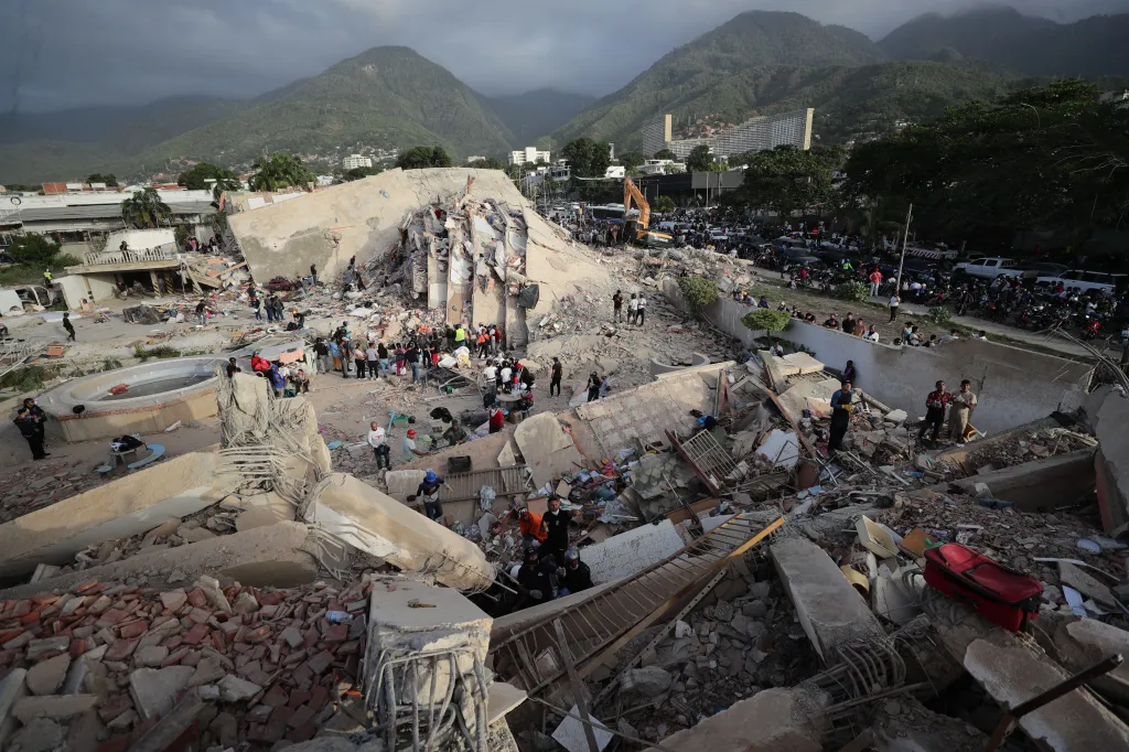Rescue workers search for survivors amidst rubble from an earthquake in La Guaira, Venezuela.
