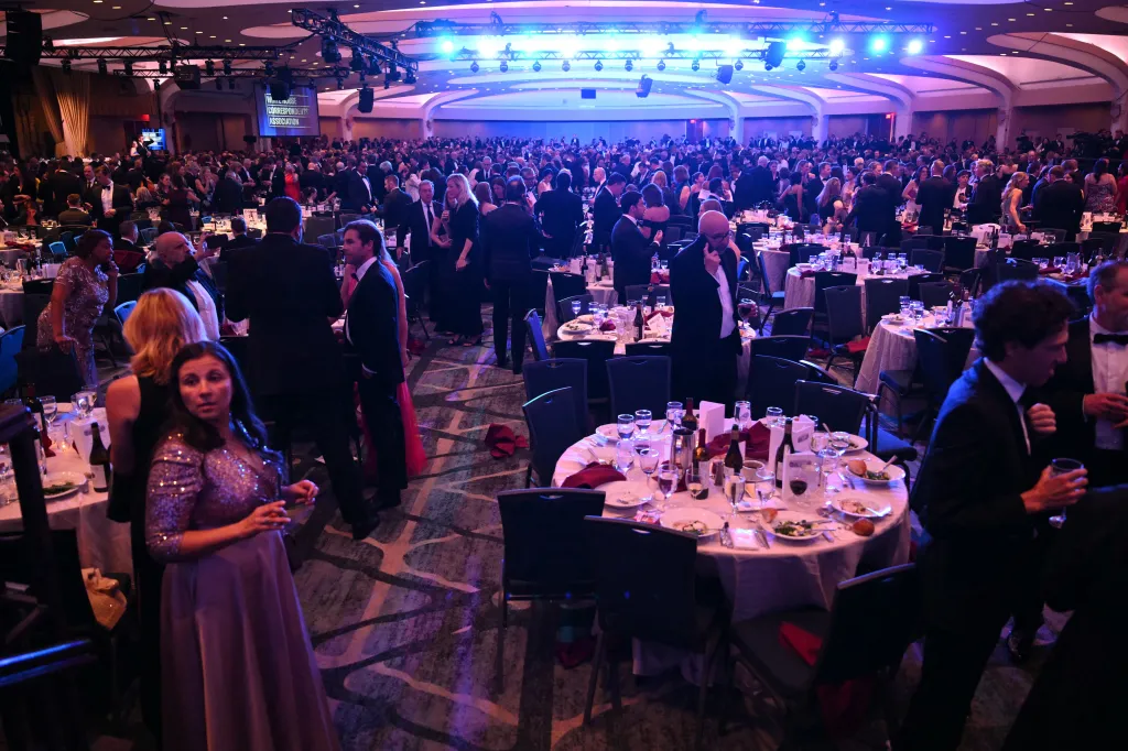 Attendees in a ballroom at the White House Correspondents' Dinner, with a screen displaying