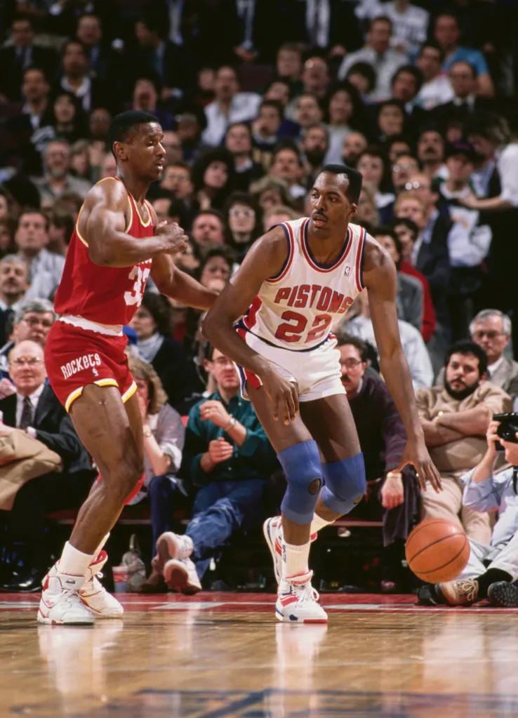 John Salley dribbling the ball for the Detroit Pistons, challenged by Otis Thorpe of the Houston Rockets.