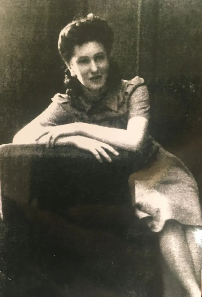 Black and white photo of Margaret Ham when she was younger, leaning on a dark surface and looking to the right.