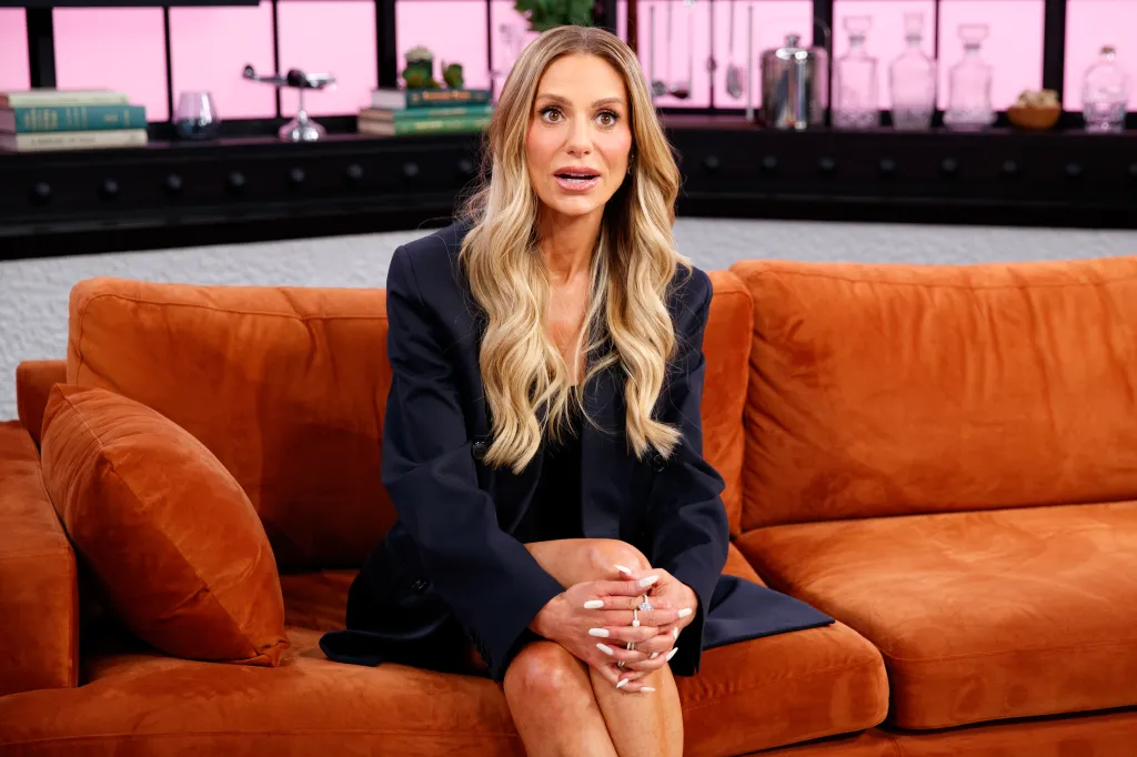 Dorit Kemsley sitting on an orange couch during an interview.