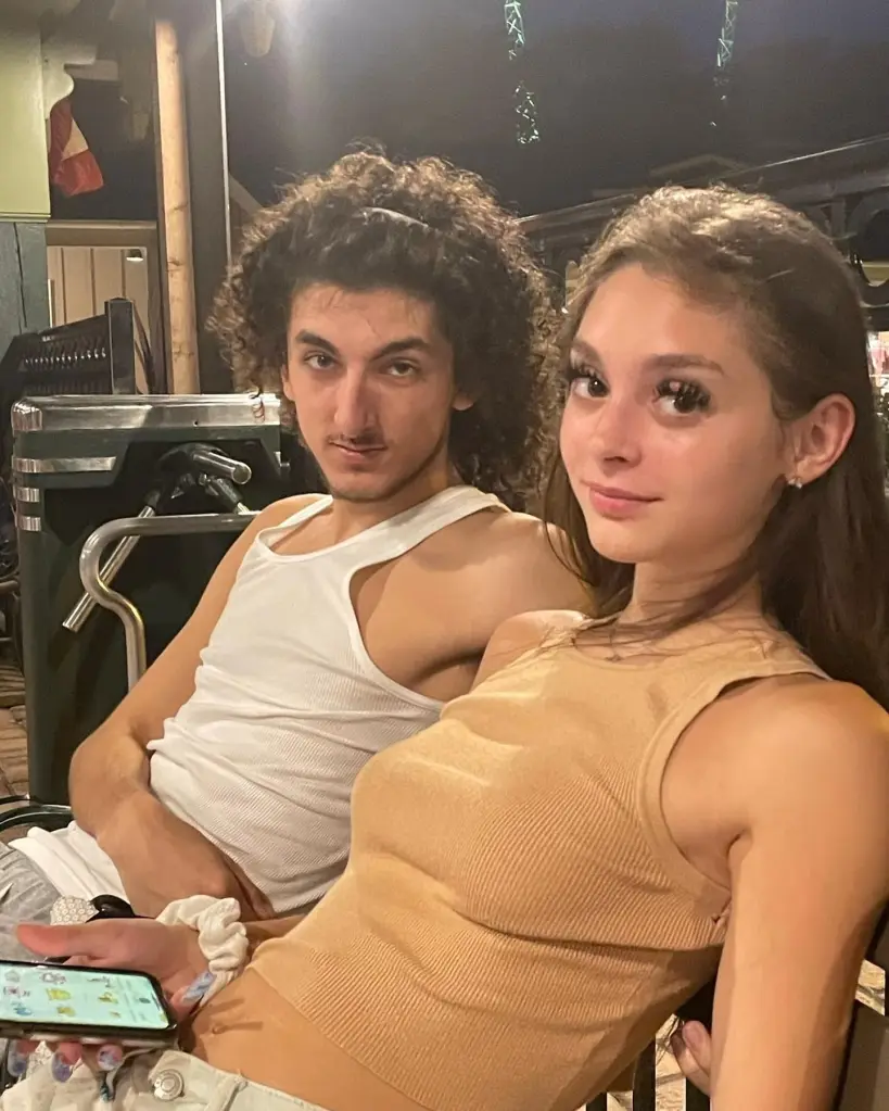 A young man and woman sitting next to each other, looking at the camera.