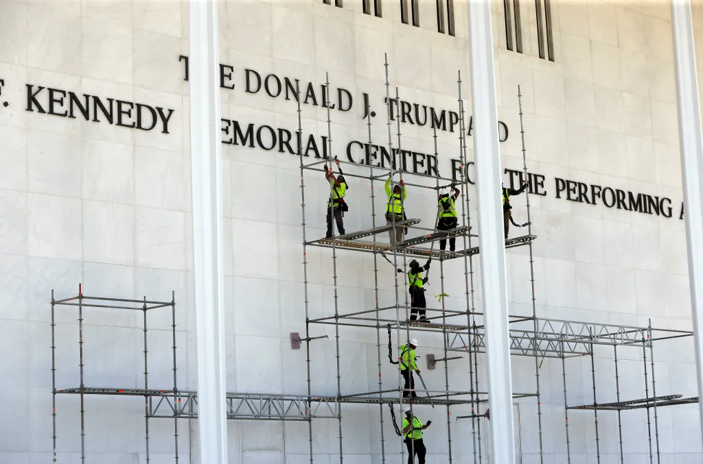 Workers remove letters that spelled "The Donald J. Trump" from the Kennedy Center building.