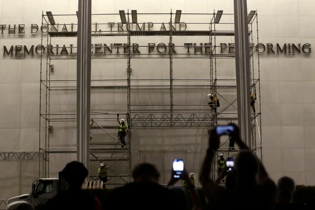 Workers remove letters spelling "Donald J. Trump" from the Kennedy Center.