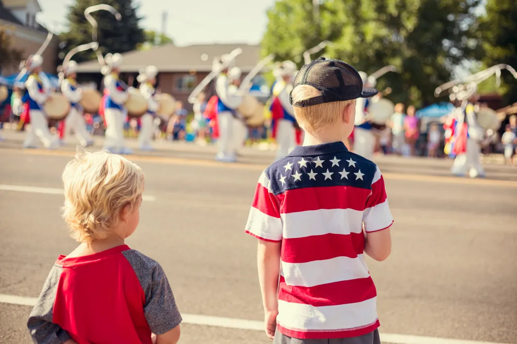 Two young boys watching an Independence Day parade.