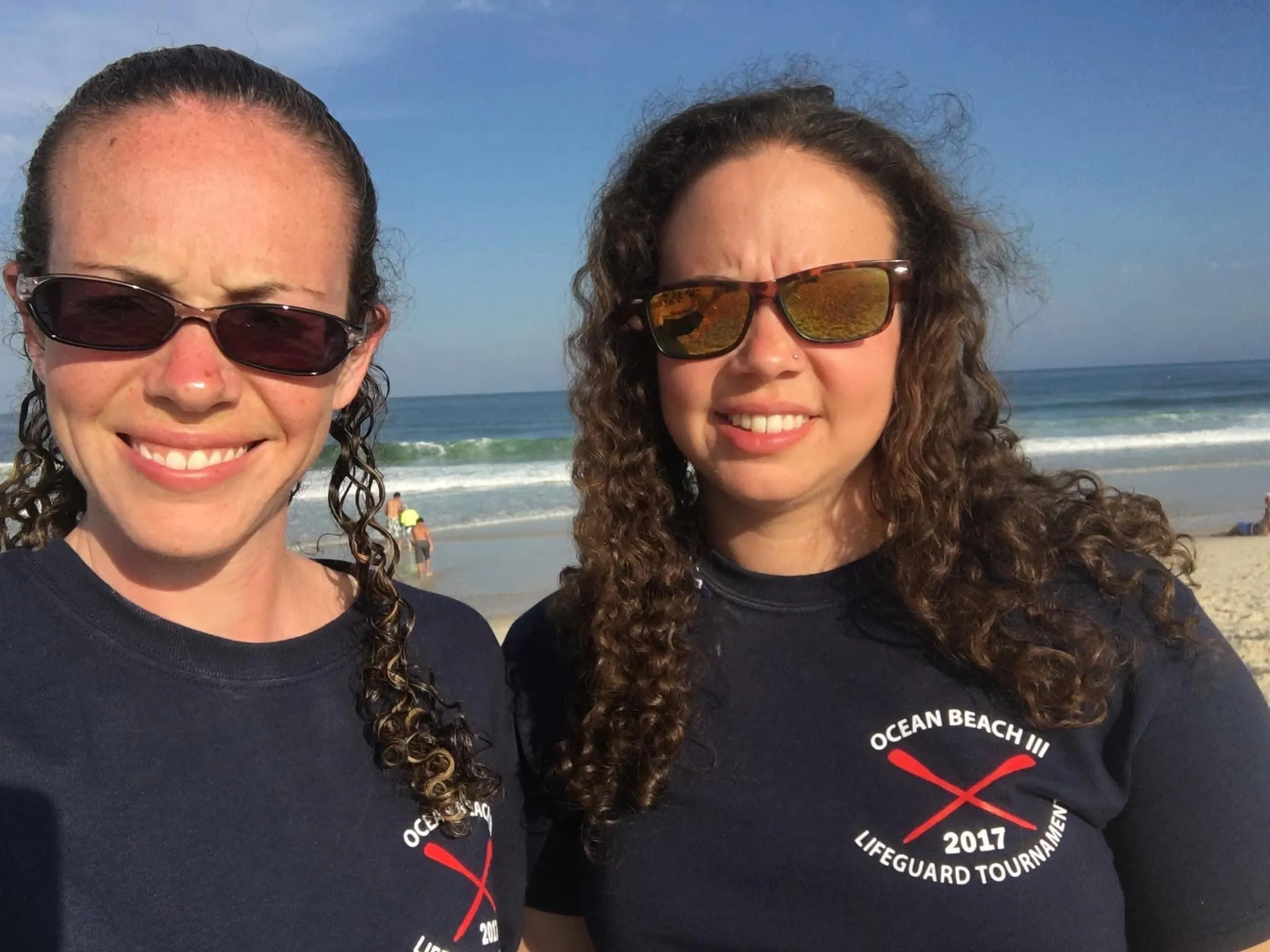 Emily Hoffman and Beth Hoffman stand together on a beach in Ocean Beach, New Jersey, in 2017, wearing sunglasses and matching dark shirts from a lifeguard tournament. Beth is on the left and Emily is on the right. Emily Hoffman and Beth Hoffman stand together on a beach in Ocean Beach, New Jersey, in 2017, wearing sunglasses and matching dark shirts from a lifeguard tournament. Beth is on the left and Emily is on the right.